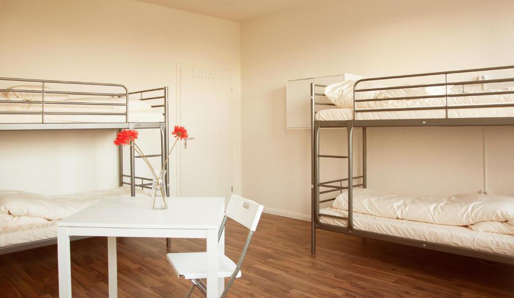 汉堡MAC城市旅舍的客房设有两张双层床、一张桌子和一张书桌。