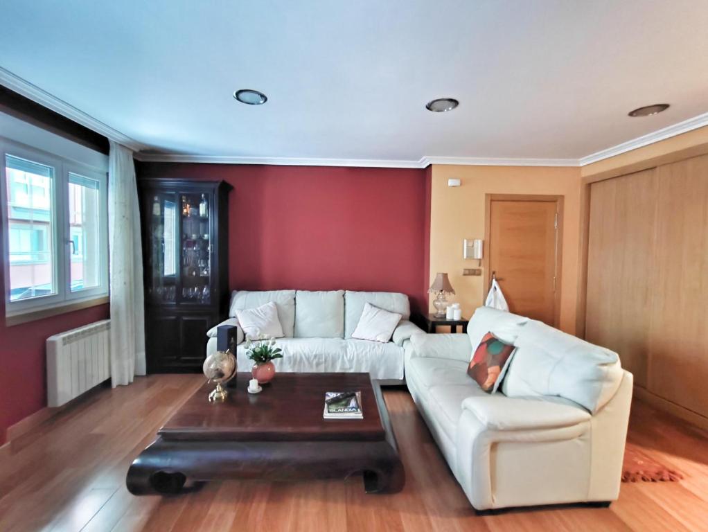 拉赫Apartamento Maya - Playa de Laxe的客厅配有白色的沙发和桌子