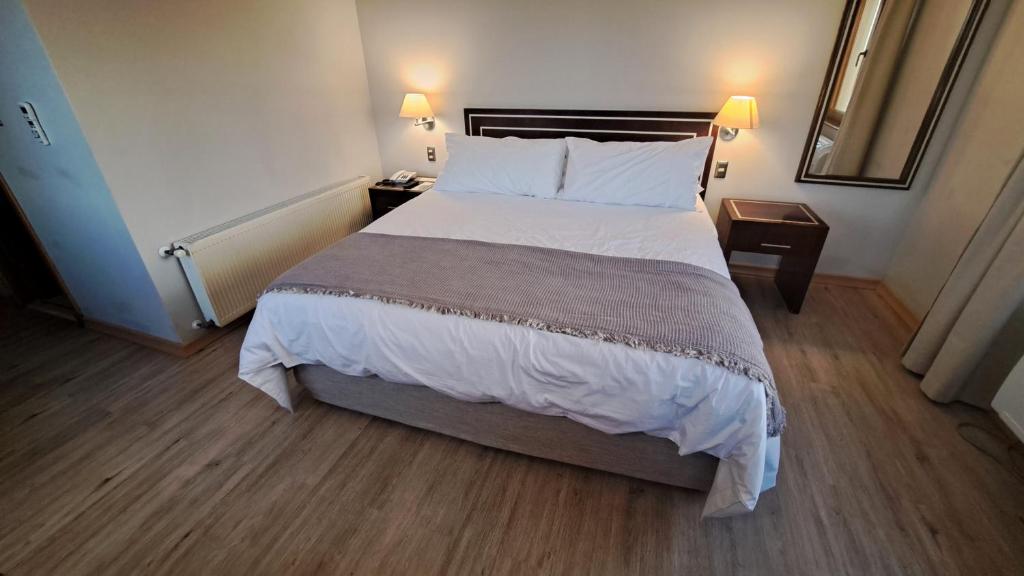 瓦尔迪维亚迭戈阿尔马格罗瓦尔迪维亚酒店的一张大床,位于酒店带两盏灯的房间