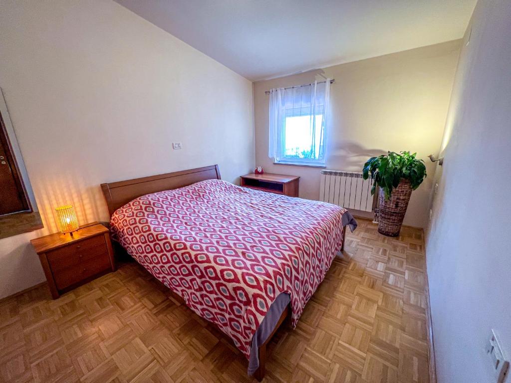 新戈里察Marta's Place的一间卧室配有一张床和盆栽植物