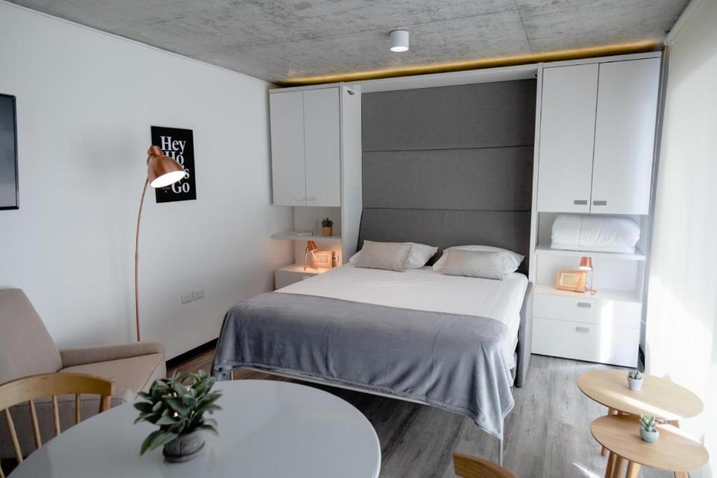 安托法加斯塔Prime Suites的一间小卧室,配有一张床和两张桌子