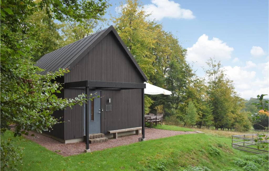 Östra SönnarslövLovely Home In stra Snnarslv With Kitchen的公园里带长凳的黑棚
