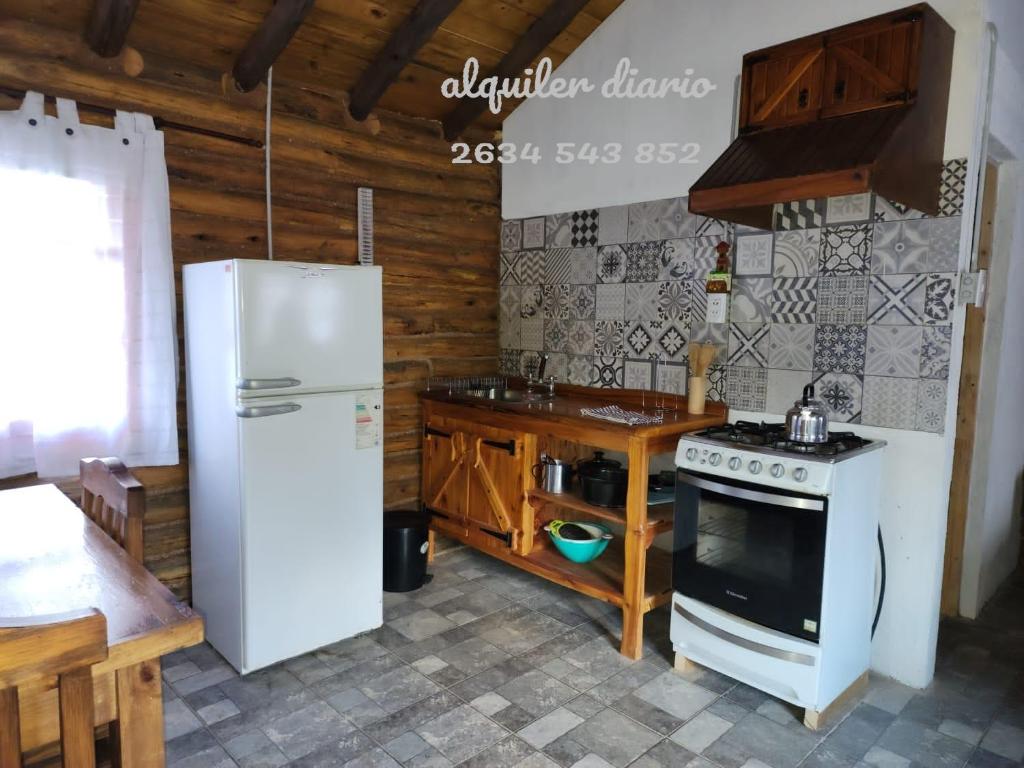 波特雷里约斯La margarita的厨房配有白色冰箱和炉灶。