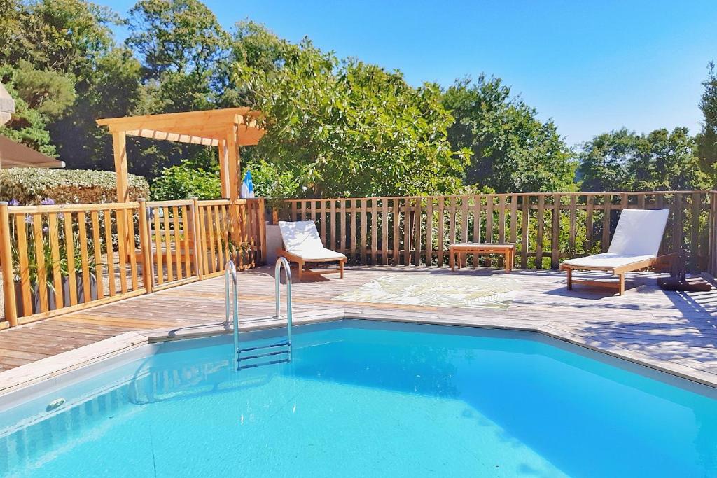 莫尔莱Villa Saint Kirio - piscine et spa的一个带两把椅子的游泳池和一个凉亭