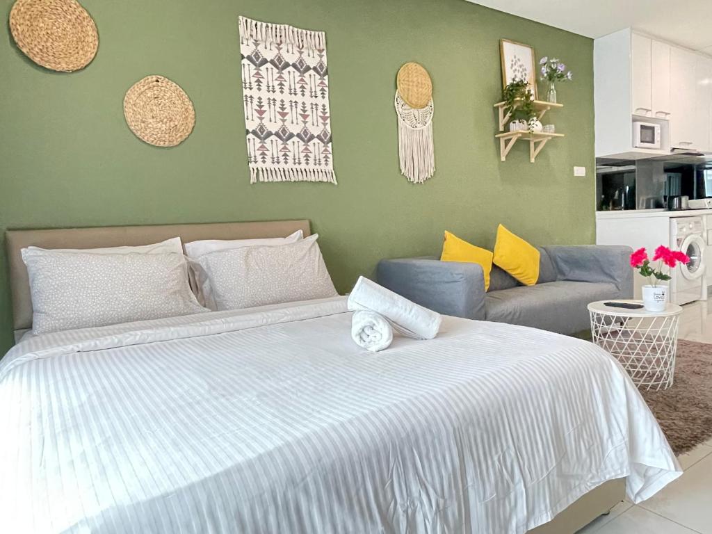 吉隆坡Mercu Summer Suite KLCC by Minshuku的一间卧室配有一张大床和一张沙发