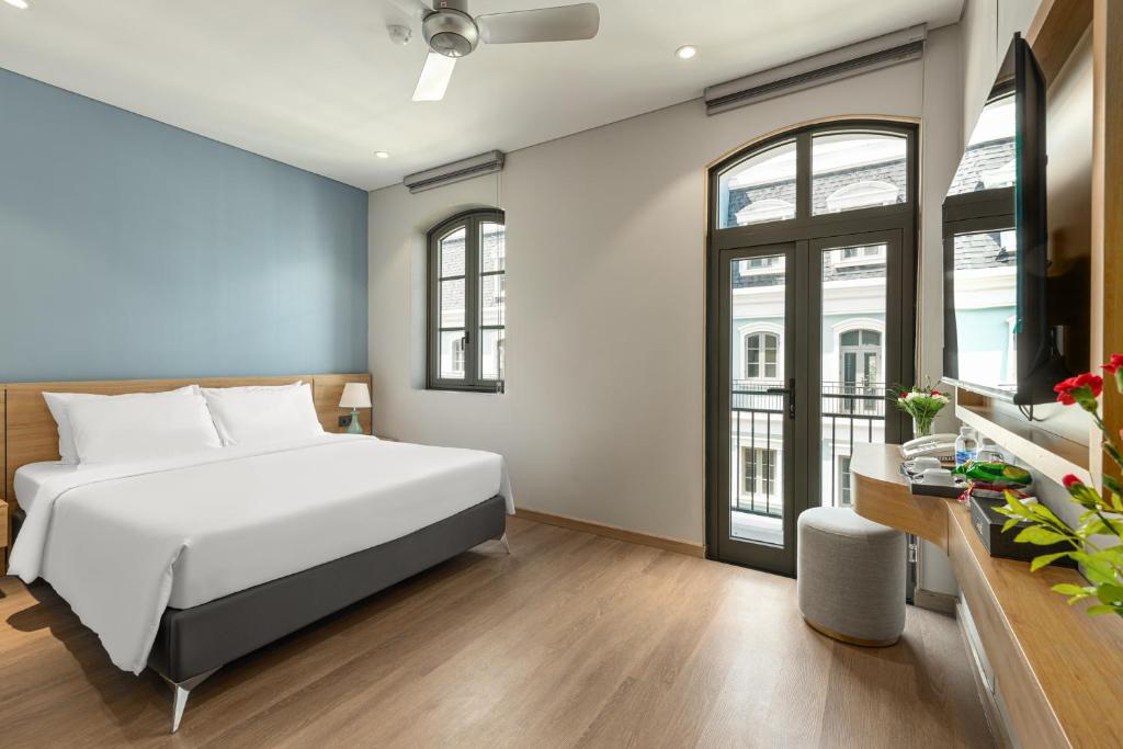 富国Laputa Hotel Phu Quoc的卧室配有白色的床和一些窗户。
