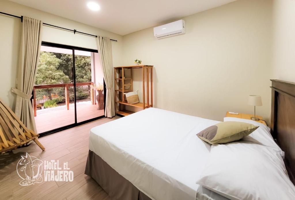 拉利伯塔德HOTEL EL VIAJERO的卧室设有一张白色大床和一扇窗户。