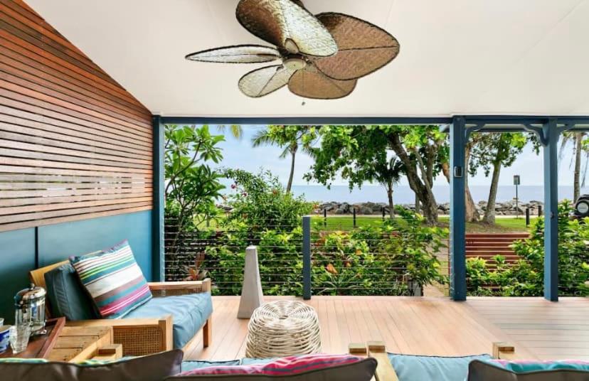 Machans BeachVilla Oshea - Balinese Beachfront Escape with Pool的客厅设有带吊扇的庭院。