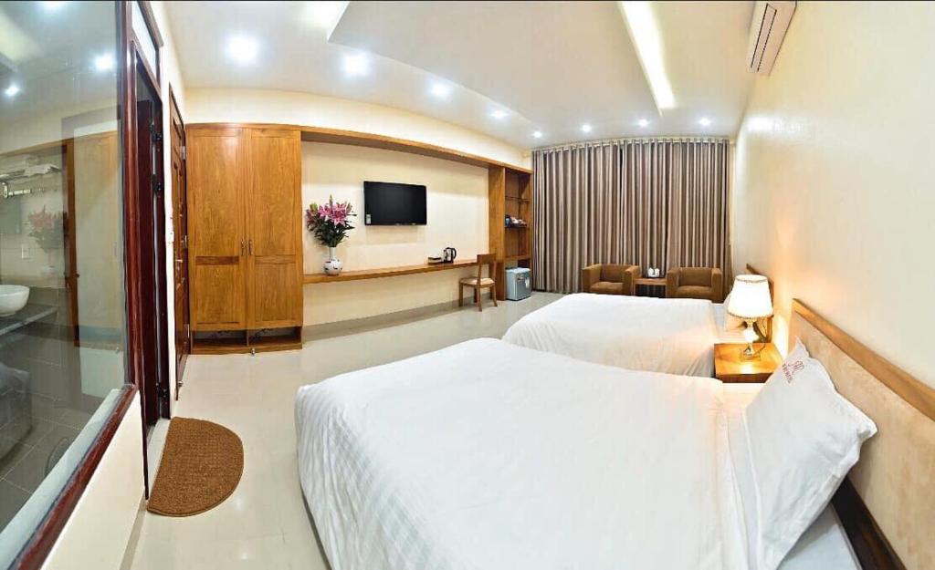 Nam ÐịnhRuby Hotel的酒店客房,配有床和电视