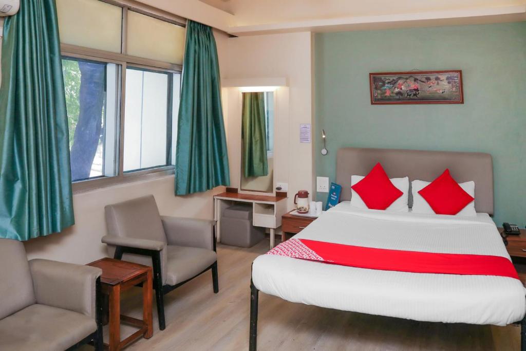 浦那Super Collection O Hotel Pearl Near Shaniwar Wada的一间卧室配有一张床、一张桌子和一把椅子