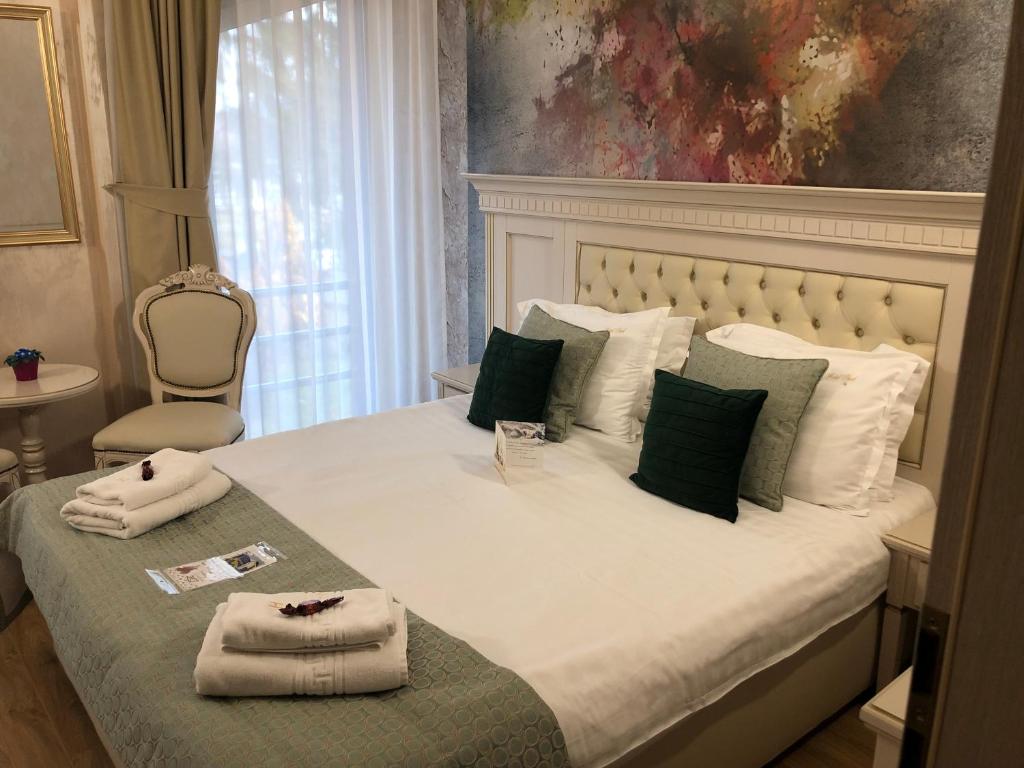 普雷代亚尔Park Luxury Rooms的一间卧室配有一张大床和毛巾