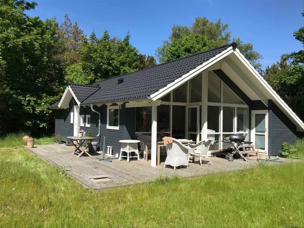 JægersprisNewer Holiday Home In Green Surroundings的房屋设有躺椅和烧烤设施