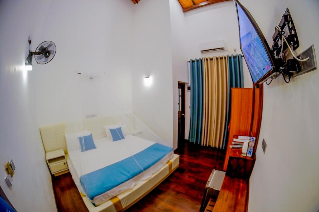 瓦伊卡尔Even Beach Resort的一间卧室配有一张床和一台平面电视