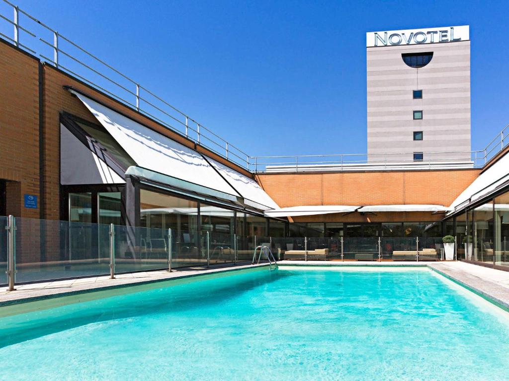 米兰米兰诺富特利纳德机场酒店的大楼前的大型游泳池