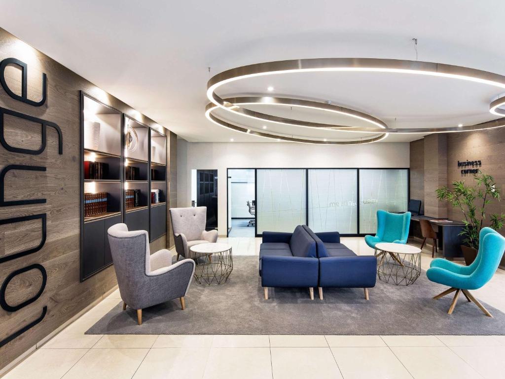 拉科鲁尼亚拉科鲁尼亚宜必思尚品酒店的一个带蓝色沙发和椅子的办公室大堂