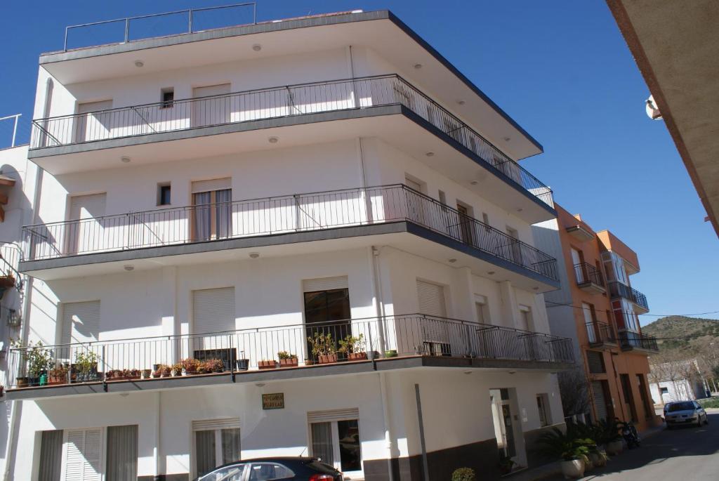 兰卡Hostal Gran Sol的白色的建筑,在街上设有阳台