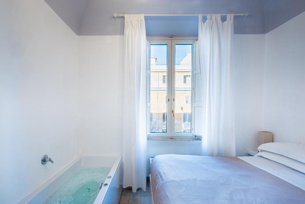 罗马My Tiny Home Alchemy的卧室设有一张床和一个靠窗的浴缸
