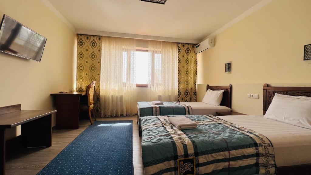 布哈拉2nd floor的酒店客房设有两张床和窗户。