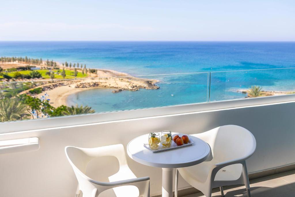 普罗塔拉斯水晶温泉海滩酒店的海滩景阳台配有桌椅