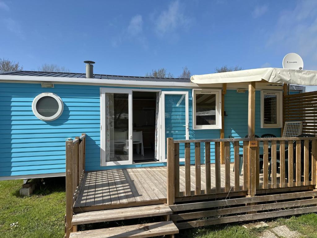 圣乔治-德迪多讷mobil home 6 places tout confort的蓝色的小房子,设有木甲板