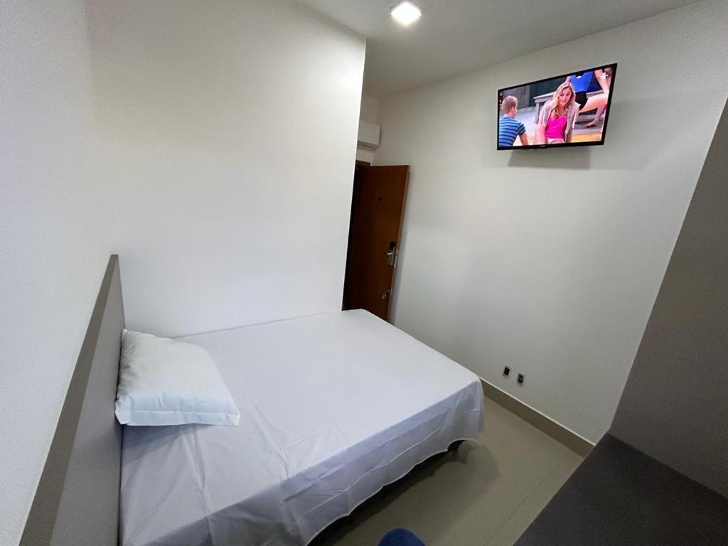 乌贝兰迪亚NANO Suítes的小房间设有一张床和墙上的电视