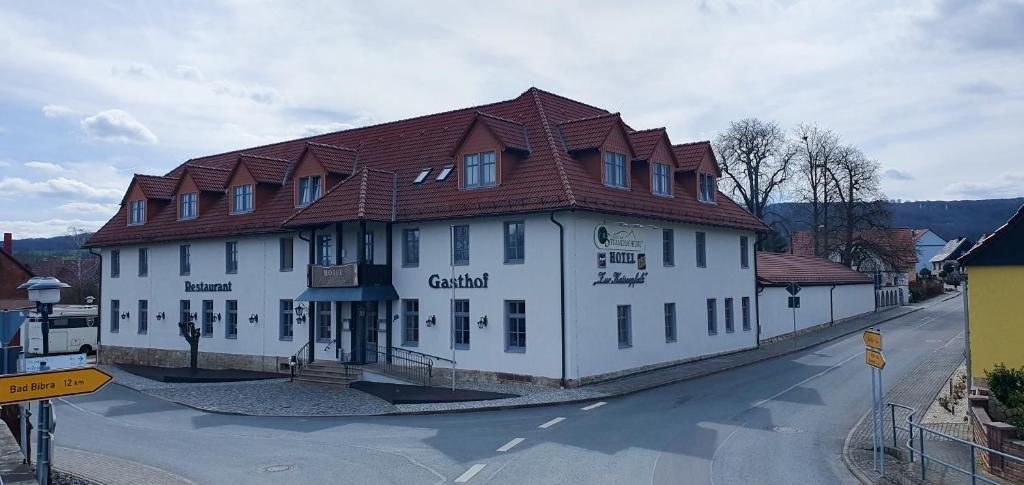 WohlmirstedtZur Kaiserpfalz的一条白色的大建筑,在街上有棕色的屋顶
