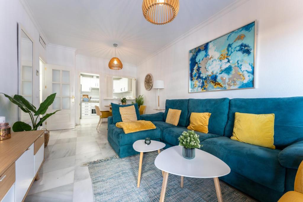 福恩吉罗拉Doña Sofía的客厅配有蓝色的沙发和黄色的枕头。