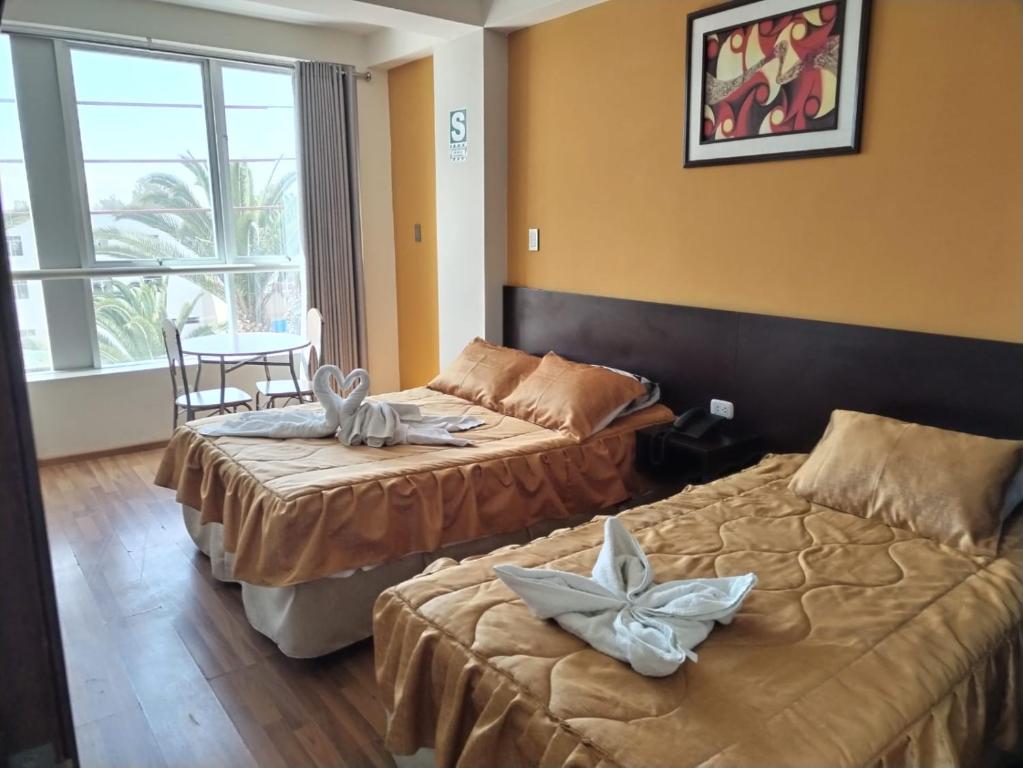塔克纳Hotel Dubái的酒店客房设有两张床和一张桌子。