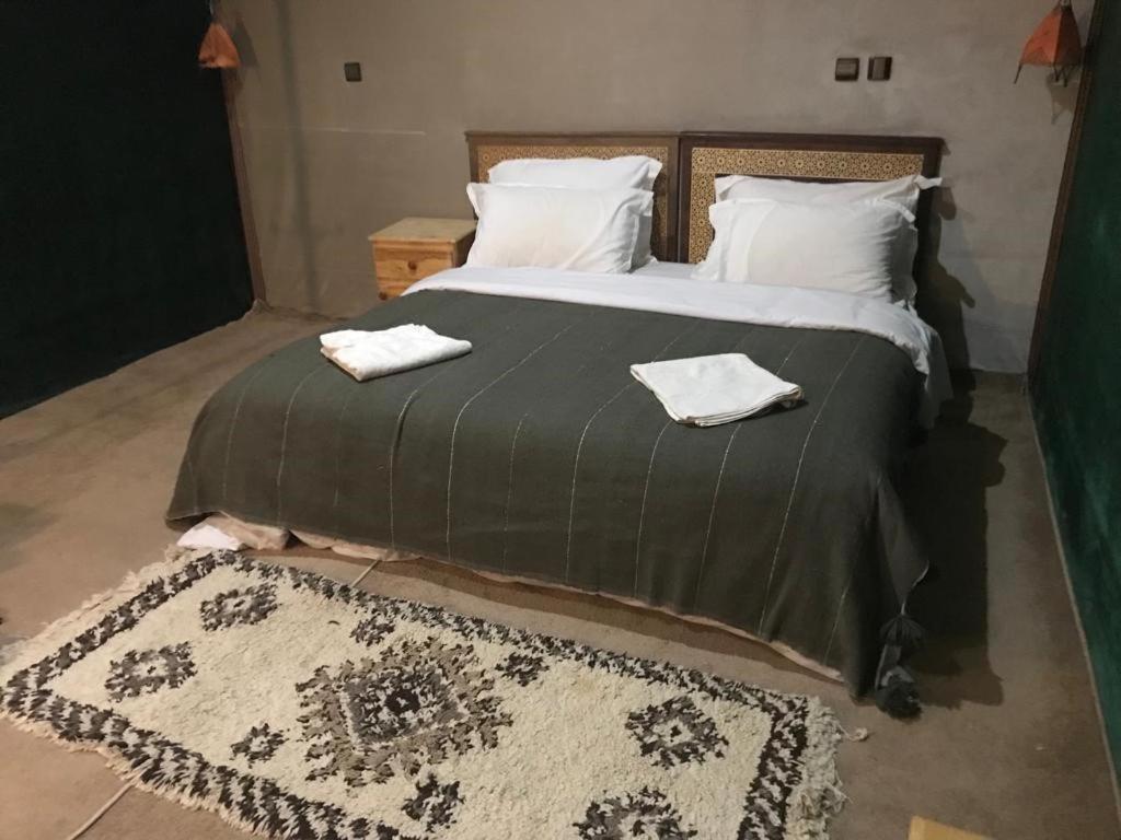 马拉喀什Camp birds traquets of SaharaProject house mars six doors的一间卧室配有一张大床和两条毛巾