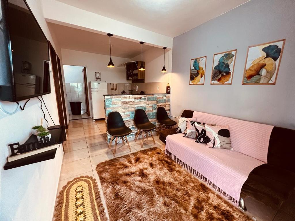 圣佩德罗-达阿尔德亚Apto Aconchego da Aldeia próximo ao centro e praias的客厅配有粉红色的沙发和椅子