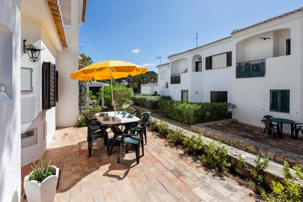 韦尔都勒博Villa Isabel的庭院配有桌椅和遮阳伞。