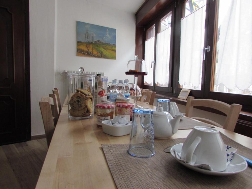 利莫内皮埃蒙特La Casa dei Gatti的餐桌,配有带罐子的长木桌