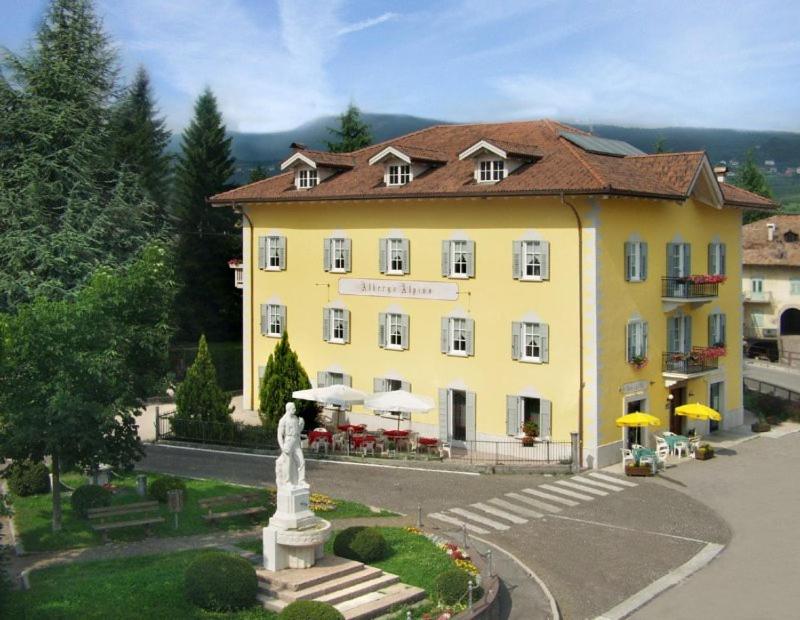布雷斯高山客栈酒店的前面有雕像的黄色建筑