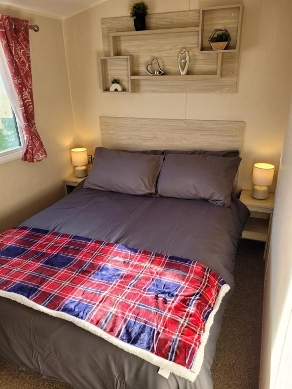 Saint OsythSeawick Holiday Park的一张位于带两盏灯的小房间的床