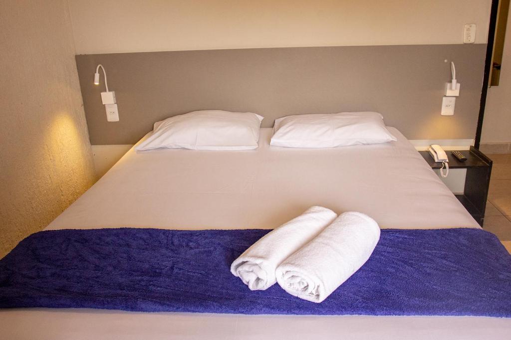 巴西利亚Hotel Montana Aeroporto的一张床上有两卷毛巾