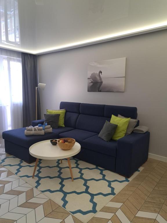 奥古斯图Apartament Augustów SWAN的客厅配有蓝色的沙发和桌子