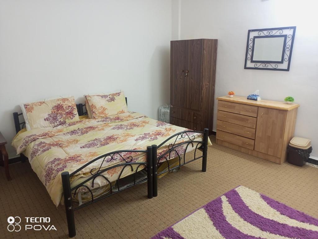 乌姆盖斯Baiet AL-Deafah Guest house的一间卧室配有一张床、梳妆台和镜子