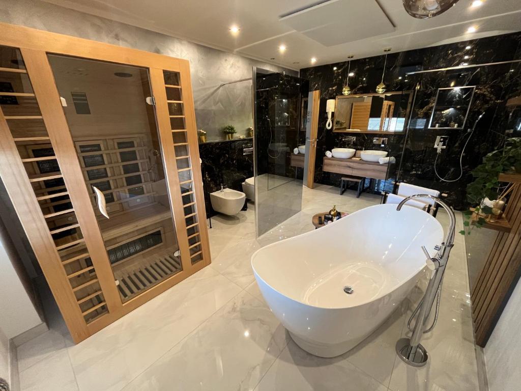 普利特维采湖Afrodita Wellness Essence的浴室配有白色浴缸和水槽