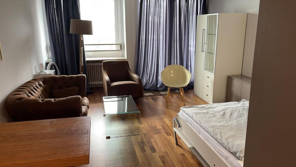 慕尼黑Apartment in München的一间卧室配有一张床、一张沙发和一把椅子