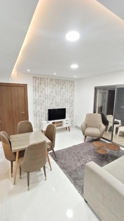 哈马马特Sublime appartement le Palace Hammamet Nord Mrezga的客厅配有桌椅和钢琴