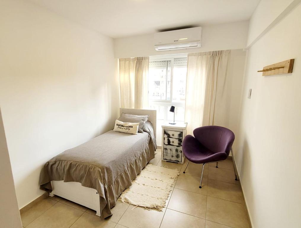 罗萨里奥Dpto. nuevo, luminoso, 3 dormitorios, pleno centro的卧室配有床、椅子和窗户。