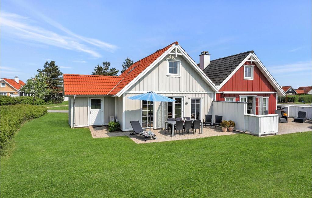 布罗Cozy Home In Brenderup Fyn With Wifi的一座白色的房子,有橙色的屋顶和院子