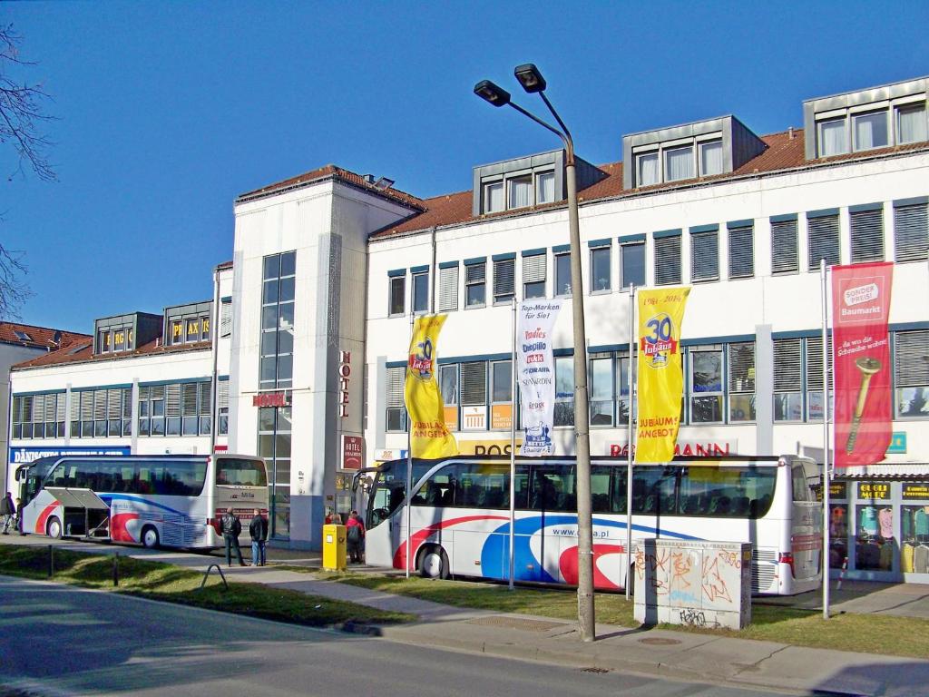 柏林柏林阿马德斯皇家酒店的停在大楼前的两辆公共汽车