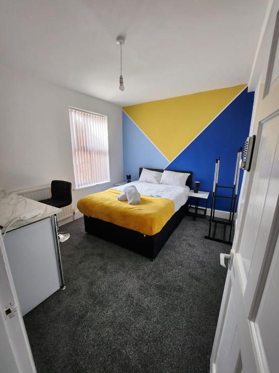 伯明翰Bamville Shared House的一间卧室设有一张床,墙壁为蓝色和黄色