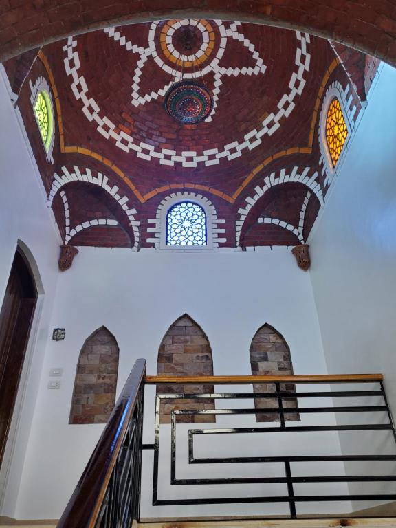 Al AqālitahLaila Flat的建筑天花板上一幅画作的楼梯