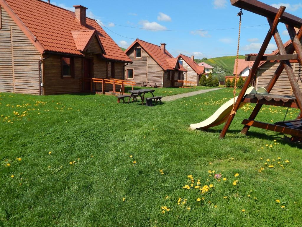 KacwinCaloroczne Domki w Gorach"ALEKSANDER"的一个带滑梯的游乐场,位于带房屋的庭院内