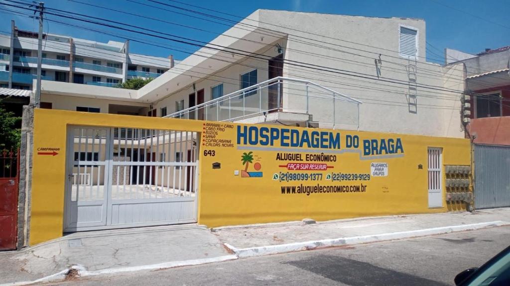 卡波布里奥Cabo Frio - Braga - Kitnets - Aluguel Econômico的黄色的建筑,旁边标有标志