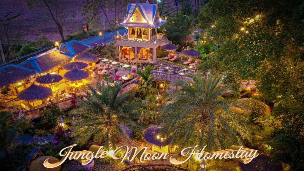 梭桃邑Jungle Moon Homestay จังเกิ้ลมูน โฮมสเตย์ บางเสร่的享有带桌子和遮阳伞的度假村的顶部景色