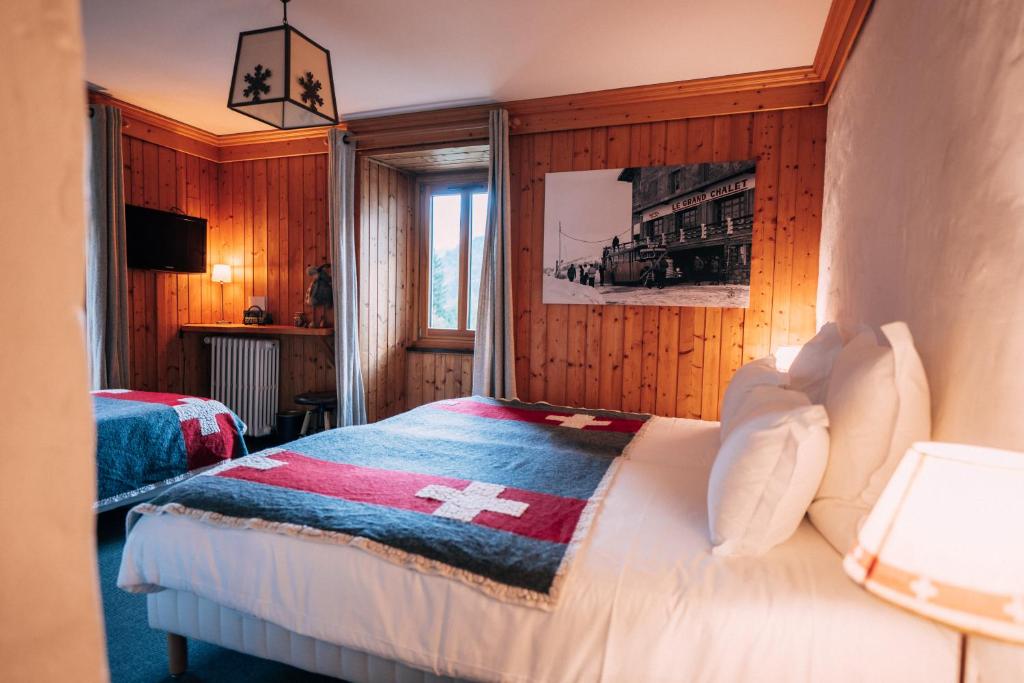 莱孔塔米讷蒙茹瓦Chalet-hôtel Gai Soleil的一间卧室配有一张带交叉毯子的床