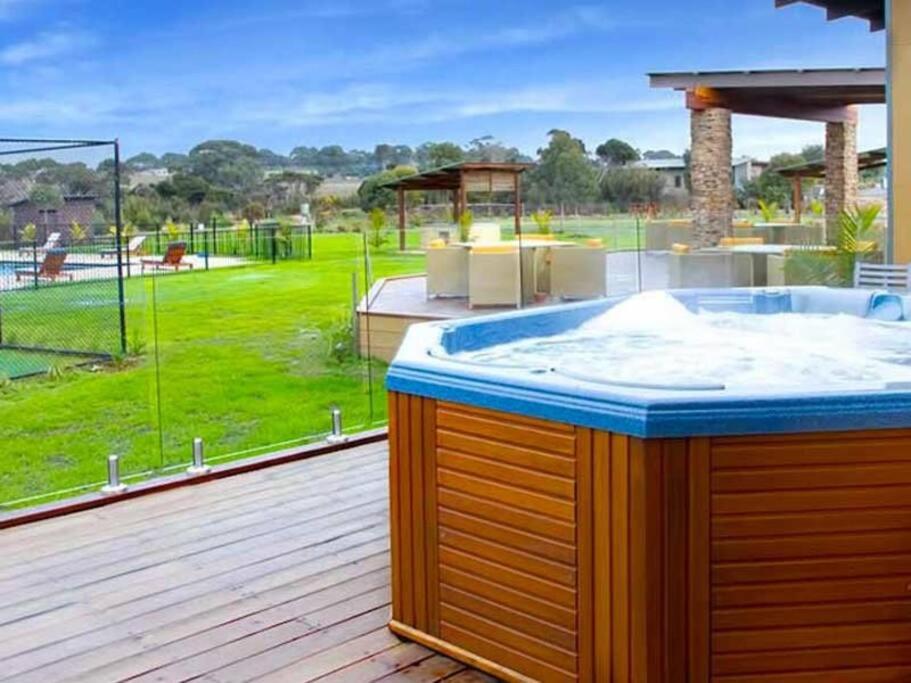 卡尔斯241 - Modern Exclusive Resort Villa w Pool Spa & Gym的享有庭院景致的甲板上的热水浴池